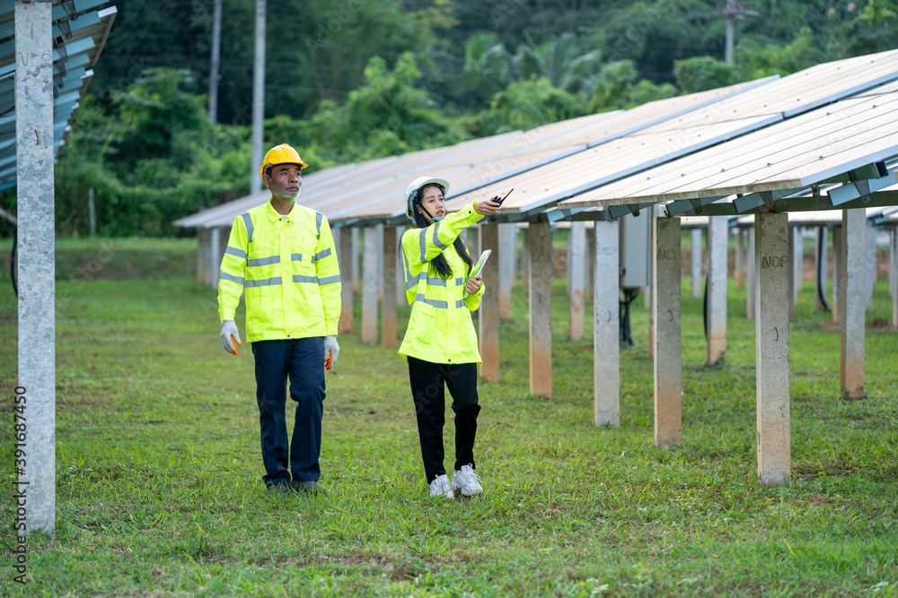 Poster technicians and engineer in long sleeve shirts reflective vests and hard hats discussing something a