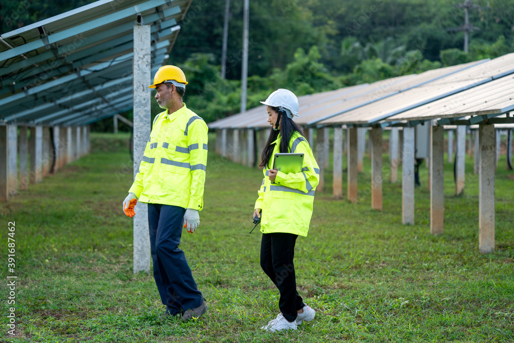 Poster technician walked along with an engineer to inspect the solar panel,engineers checking solar panels.