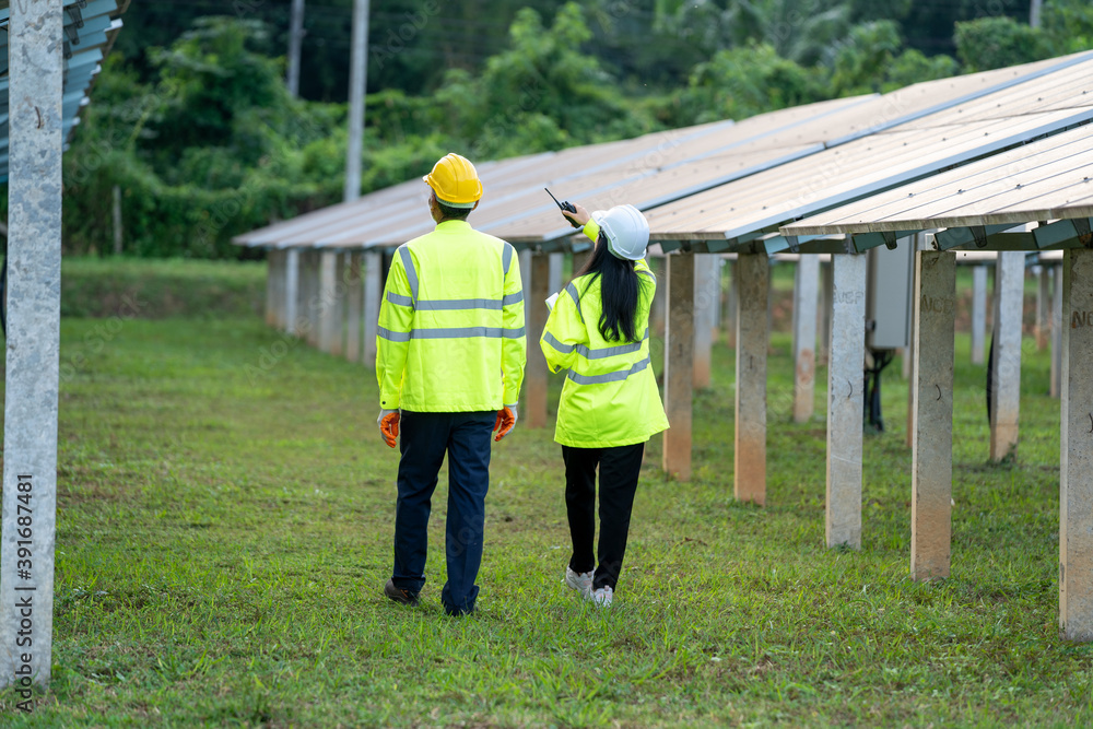 Poster technician walked along with an engineer to inspect the solar panel,engineers checking solar panels.