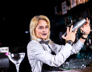 Girl barman formulates a cocktail at the beerhouse