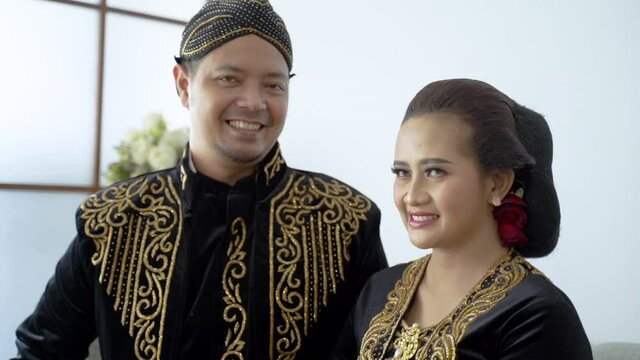 happy men and women wearing javanese traditional clothes. beskap and kebaya for java wedding