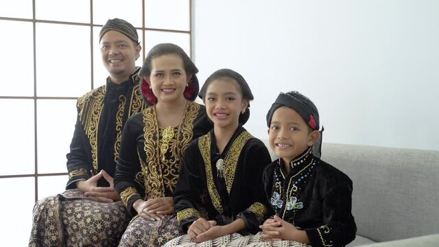Portrait of a happy family wearing traditional Javanese clothes. concept of family photo with kebaya and beskap java wedding dress