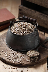 sunflower seeds in measuring cup on the wooden background