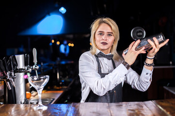 Girl bartender creates a cocktail on the brasserie