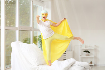 Little girl wearing superhero costume in clinic. Childhood cancer awareness concept