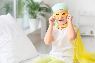 Little girl wearing superhero costume in clinic. Childhood cancer awareness concept