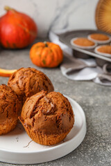 Obraz na płótnie Canvas Plate with tasty pumpkin muffins on table