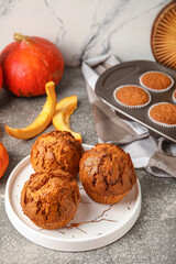 Plate with tasty pumpkin muffins on table
