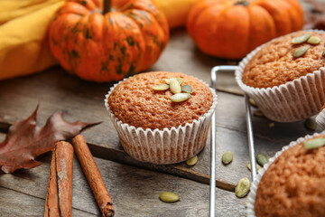 Cooling rack with tasty pumpkin muffins on table