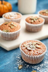 Tasty pumpkin muffins on color background