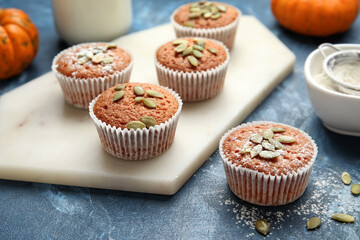Tasty pumpkin muffins on color background