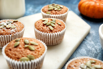 Tasty pumpkin muffins on color background