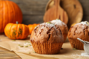 Tasty pumpkin muffins on table