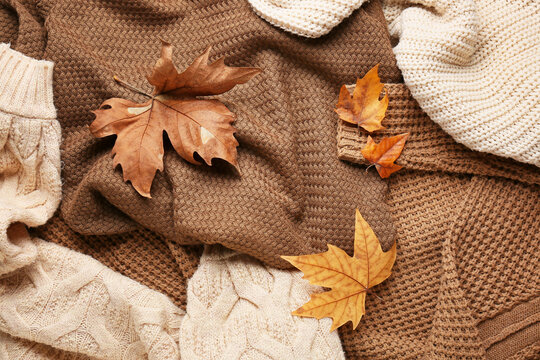 Warm autumn clothes with leaves, top view