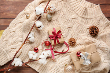 Christmas composition with stylish clothes and gifts on wooden background