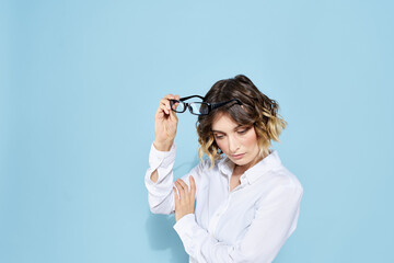 Business woman in a light shirt on a blue background gestures with her hands emotions model work