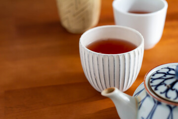 日の当たるテーブルに置かれた急須とほうじ茶の入った湯飲み