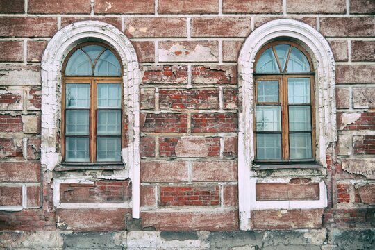 Details of the facade of the old building, an old shabby wall, a decorative wooden windows aperity