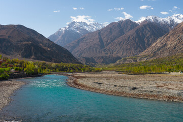 Fototapeta na wymiar Beautiful blue river of Ghizer view from Ghizer valley surrounded by Hindu Gush mountains range, North Pakistan