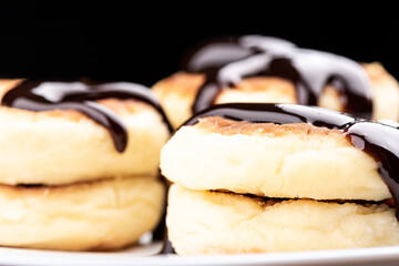 Selective focus. Close-up shot of cheese pancakes decorated with chocolate topping. Food background concept.