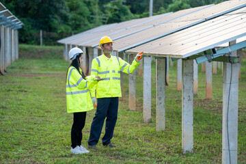 Technician working with engineer planning new ecology project around field of solar panels.