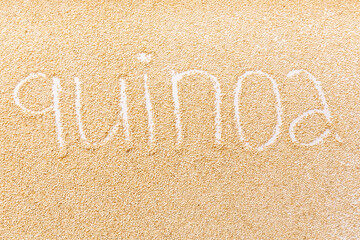 Top View of Organic Quinoa Chenopodium quinoa seeds Macro close up background texture with word Quinoa written on grains
