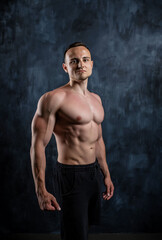Fototapeta na wymiar Handsome athletic man posing on black background.