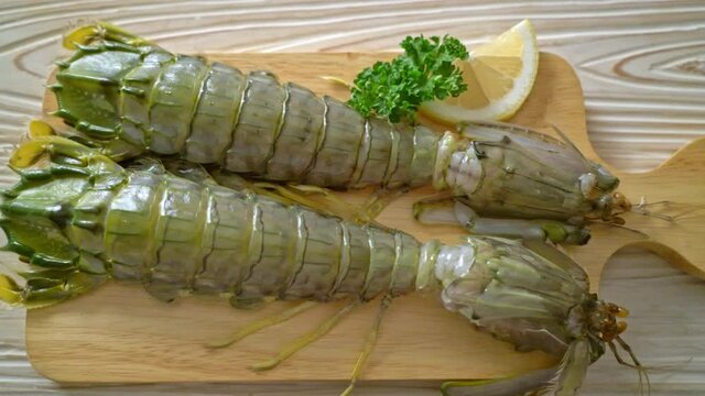 fresh mantis shrimp with lemon on wood board