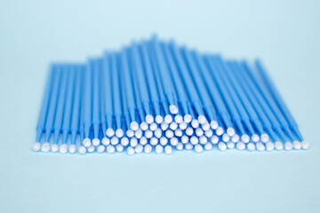Blue microbrushes, small brushes for cleaning eyelashes and teeth. Blue background. Dentistry, eyelash extensions.