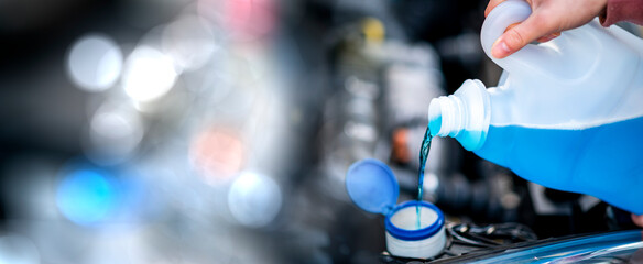 Pouring antifreeze. Filling a windshield washer tank with an antifreeze in winter cold weather.