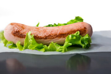 Toasted sausage with a green lettuce on the table