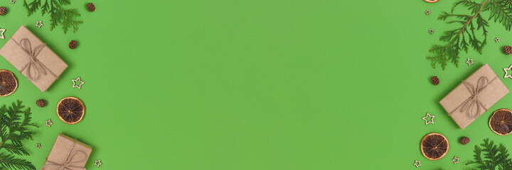 Banner with natural Christmas gifts, decorations and coniferous branches on a green background. Zero waste concept with copy space.