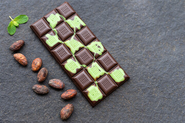 Mint chocolate on a dark stone background. Top view with copy space