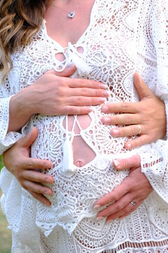 Coppia con donna incinta. Gravidanza e attesa di una coppia con vestito bianco. Abbraccio