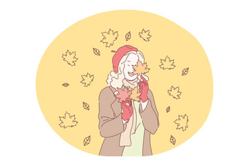Autumn, fall, colourful fallen leaves concept. Young happy girl cartoon character in stylish casual clothing and beret enjoying leaf fall from maple tree in park or in forest alone in autumn 