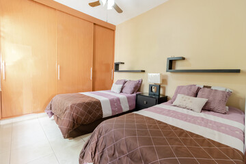 recamara con 2 camas y closet de madera, sin gente 