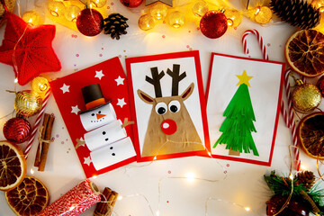 DIY Christmas cards kids. Three cards with a Christmas tree, a deer, a snowman from colored paper.