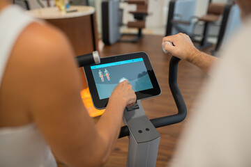 Close up picture of a persons hand pressing a touchpad on a gym machine