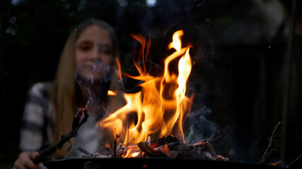Kid Playing at Campfire Adventure Outdoor in Night, Child Plays with Fire in Camp, Girl in Nature at Countryside, Rustic in Dark