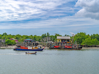 Fototapeta na wymiar Asian Fishing Village by the sea with a blue sky