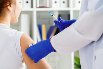 Doctor hands making a vaccination in the shoulder of patient