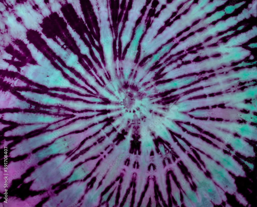 Wall mural spiral tie dye texture. hippie tie-dye wallpaper. boho festival tiedye background in purple green.