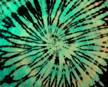 Spiral tie-dye pattern. Hippie tie dye wallpaper. Tiedye background in rainbow pastel green yellow.