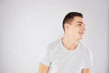 Man in a white t-shirt emotions gestures with hands close-up cropped view light background