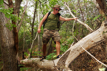 a man walking on a fallen tree