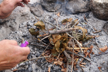 man's hands kindle a bonfire close up