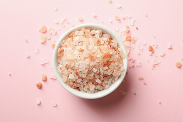 Bowl of pink himalayan salt on pink background