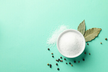 Bowl of salt and spices on mint background
