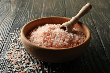 Bowl of pink himalayan salt and scoop on wooden table