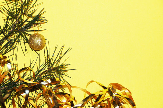 Spruce Branch With Golden Balls And Tinsel On A Yellow Background, Christmas Card